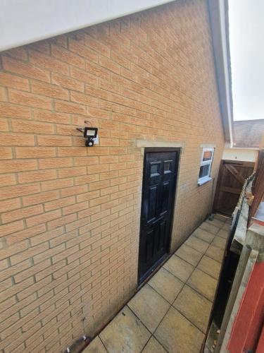 a brick wall with a door and a cat on it at The Suite in Grays Thurrock