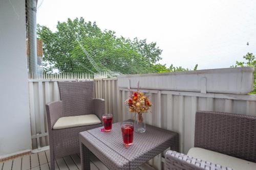 a table with two glasses and flowers on a patio at Exclusive 2-Room-City-Apartment - Contactless Check-in in Hannover