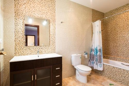 a bathroom with a toilet and a sink and a mirror at Villa Inia - PlusHolidays in Calpe
