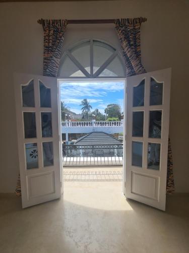 an open door with a view of a beach through it at Linda's Little Lincoln in Watamu