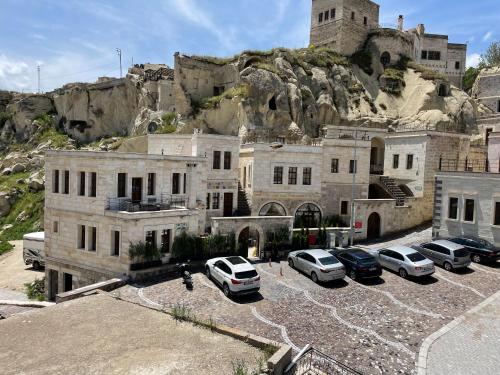 a large building with cars parked in a parking lot at Doctor's Cave Cappadocia in Urgup