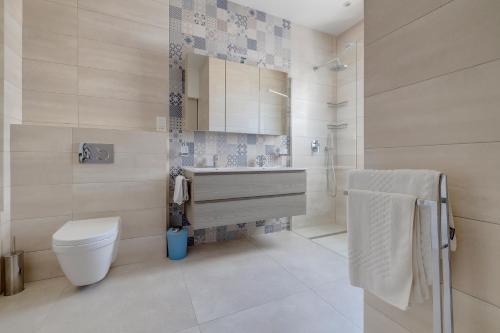 a bathroom with a toilet and a sink and a shower at Lux Penthouse Valley Views Hot Tub in Siggiewi in Siġġiewi