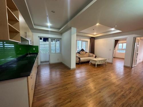 eine Küche und ein Wohnzimmer mit einem Sofa und Holzböden in der Unterkunft Chung cư TDC Plaza in Hòa Lợi (2)