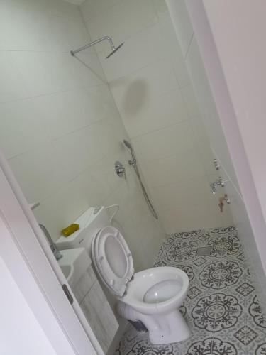 Baño blanco con aseo y lavamanos en יחידת דיור נפרדת עמק המעיינות בית שאן en Bet Sheʼan