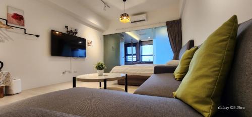 uma sala de estar com um sofá e uma televisão em 楓葉閣溫泉會館Hot Spring Hotel em Hsin-hsing