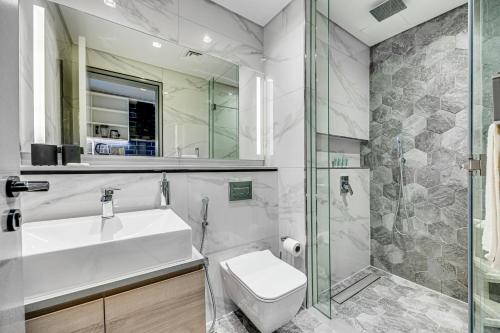 een badkamer met een wastafel, een toilet en een douche bij Stylish canal view apartment in Business Bay in Dubai
