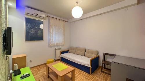una pequeña habitación con una cama y una mesa en Lorono Kosta, en Belgrado