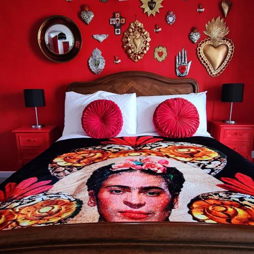 a bed with a painting of a presidents head on it at Frida's Cottage Whitby in Whitby