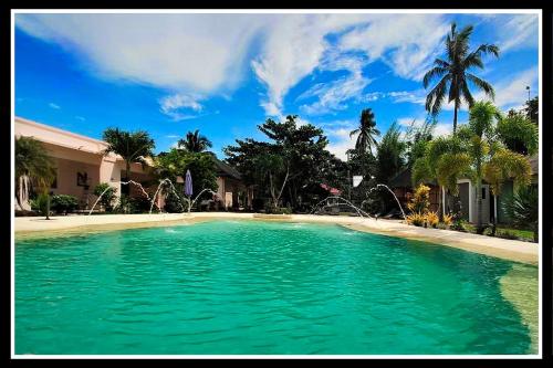 a large pool of green water in front of a house at Imagine-Bohol in Panglao Island