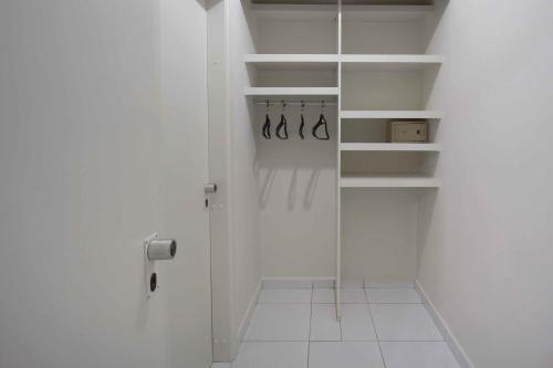 a white walk in closet with white shelves at Bristol Metropolitan Curitiba Centro in Curitiba