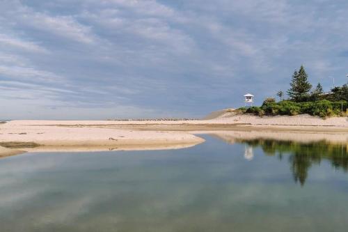 a body of water with a lighthouse in the background at Waterview luxury hideaway, 2 min walk to all, pool in The Entrance