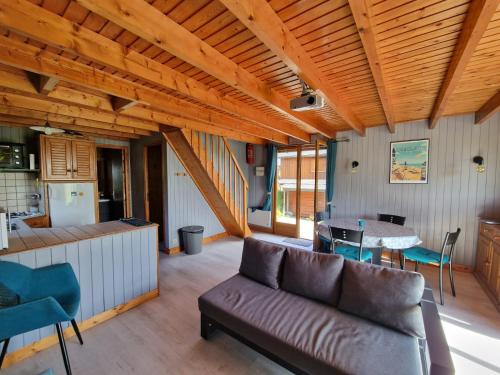a living room with a couch and a table at Chalet 6 pers avec piscine in Cabourg