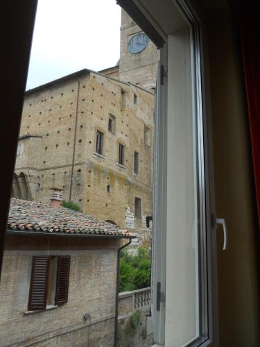 a window view of a building with a clock tower at Albergo Italia in Urbino
