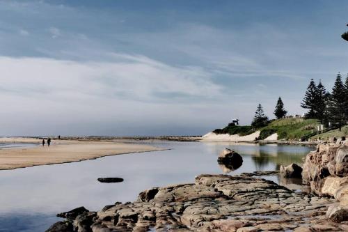 a view of a beach with rocks and water at Waterview luxury hideaway, 2 min walk to all, pool in The Entrance