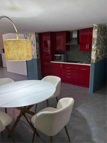 a kitchen with red cabinets and a white table and chairs at A un passo dal Castello Maschio ANGIOINO Appartment in Naples