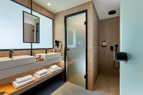 a bathroom with two sinks and a shower at Sentido Amounda Bay in Amoudara Herakliou