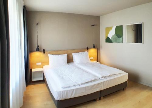 sypialnia z dużym łóżkiem z białą pościelą w obiekcie Marida Hotel w mieście Satu Mare
