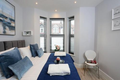 ein Schlafzimmer mit einem großen Bett mit blauen Kissen in der Unterkunft Aisiki Apartments at Stanhope Road, North Finchley, Airconditioned Multiple 2 or 3-Bedroom, Pet Friendly Duplex Flats, King or Twin Beds with Free Wi-Fi in Finchley