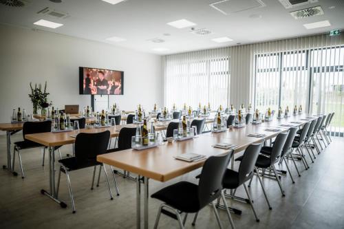 a large room with tables and chairs and a screen at i - PARK Hotel Reichenberg in Reichenberg