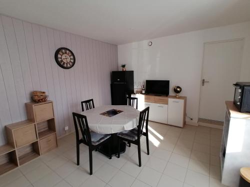 une cuisine avec une table et des chaises dans une pièce dans l'établissement Appartement en bord de mer entre Saint Malo et le Mont Saint Michel, à Saint-Benoît-des-Ondes