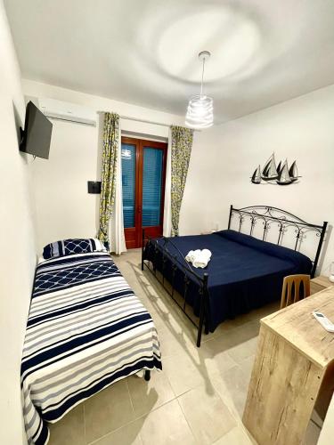 a bedroom with two beds and a table at B&B Cala Del Borgo in Santa Maria