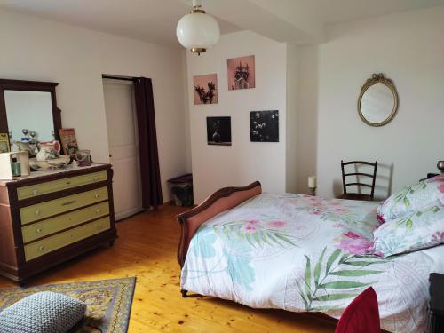 een slaapkamer met een bed, een dressoir en een spiegel bij Chambre de Charme in Mirepoix