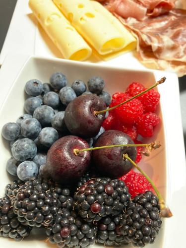 a tray filled with berries and blueberries and cheese at Chez Roya in Zaventem