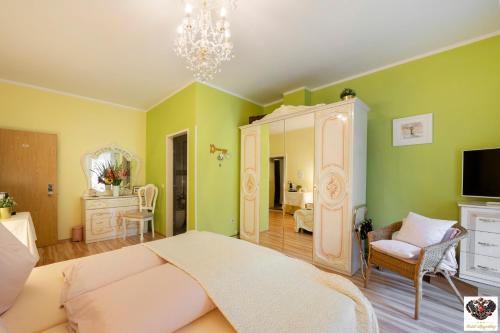 a bedroom with green walls and a bed and a mirror at Hotel Mayerling in Mayerling