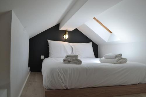 une chambre avec un lit blanc avec des serviettes dessus dans l'établissement Le Cocon Filaterie, à Annecy