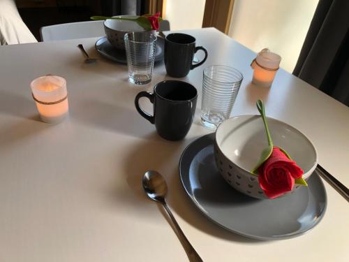 uma mesa com um copo e uma rosa num prato em Une Pause Douceur - Suite All in Wood em Eyguières