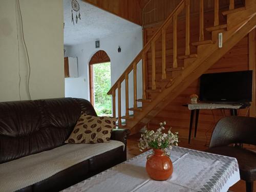 uma sala de estar com um sofá e uma mesa em Domek w Gorcach 