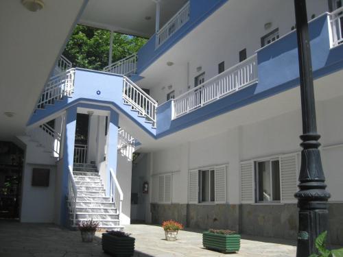 a building with blue and white stairs and a pole at Armiriki Rooms in Vrasná