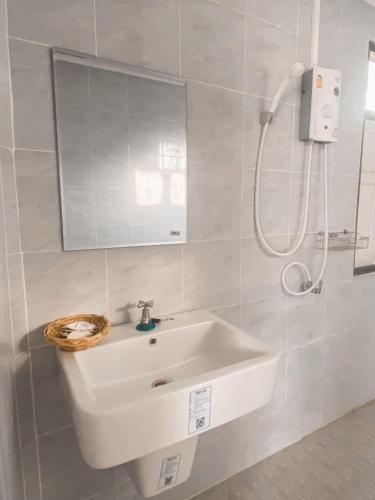 a white bathroom with a sink and a shower at Route 3228 in Ban Kao