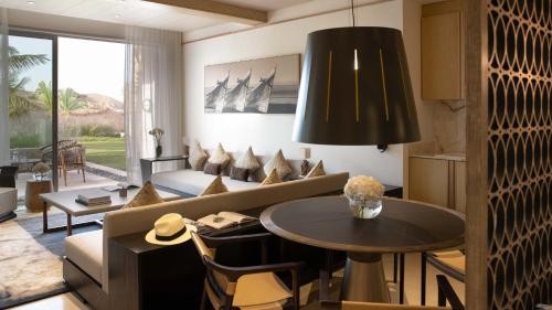 Jumeirah Muscat Bay في مسقط: غرفة معيشة مع أريكة وطاولة