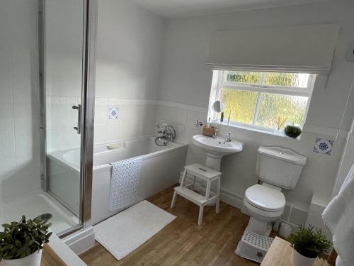 a bathroom with a shower toilet and a sink at Stunning 5 bedroom country home with amazing views in Leamington Spa