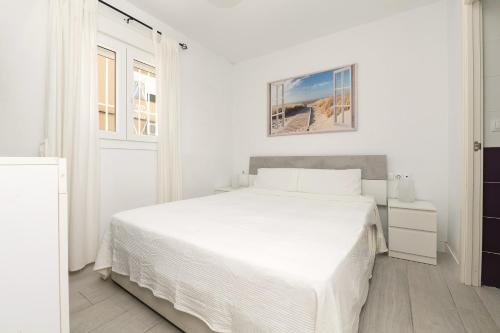 a white bedroom with a white bed and a window at AMANECER BOUTIQUE HOME, BEACH, Village & RELAX in Chiclana de la Frontera