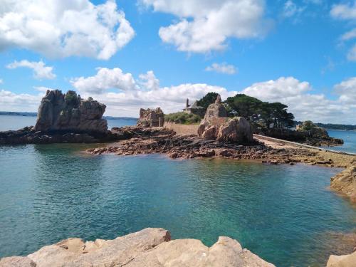a body of water with rocks in the water at chambre d'hôte proche mer in Yvias
