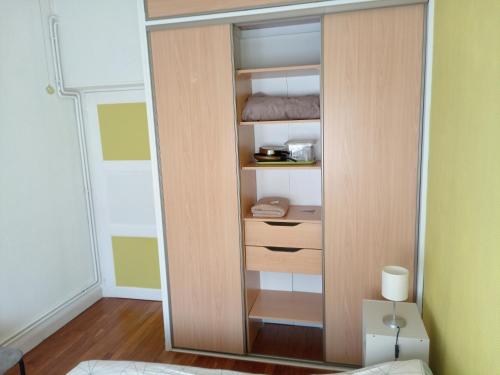 Cette chambre dispose d'un placard avec des portes en bois. dans l'établissement Chambre meublée au cœur de ville - chez l'habitant, au Creusot