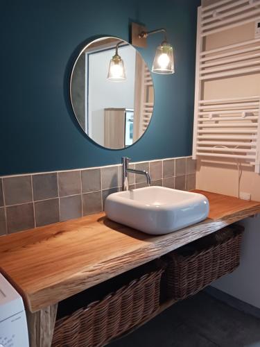 ein Bad mit einem Waschbecken und einem Spiegel in der Unterkunft chambre d'hôte proche mer in Yvias