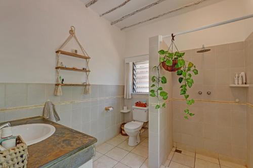 a bathroom with a sink and a toilet and a tub at Salama House - your peaceful, poolside retreat in Watamu