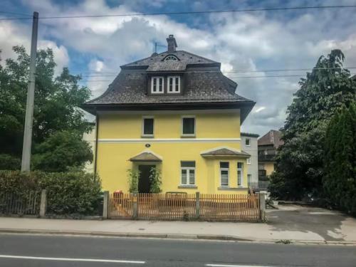 una casa gialla con tetto nero di Traditional Apartments Salzburg a Salisburgo