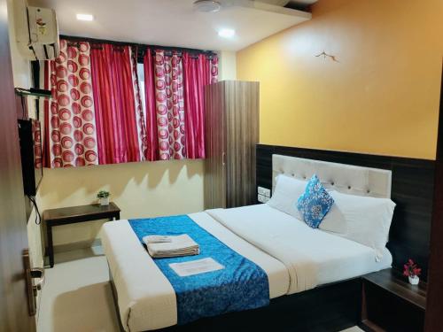 a bedroom with a large bed with colorful curtains at Hotel Golden Galaxy - Santacruz East in Mumbai