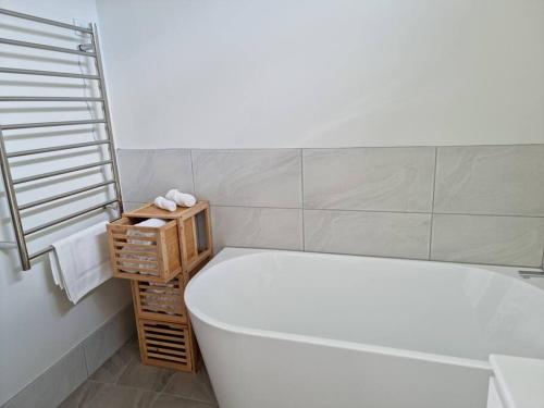 ein Badezimmer mit einer Badewanne, einem WC und einem Waschbecken in der Unterkunft Millhouse on Pine in Pemberton