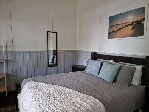 ein Schlafzimmer mit einem großen Bett mit blauen Kissen in der Unterkunft Millhouse on Pine in Pemberton