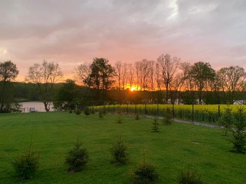 a field with the sunset in the background at MAŁY PORT-Iława - Jezioro - Plaża - Marina priv - 5 pokoi VIP - czysto na 10 in Iława