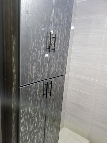 un bagno con box doccia con due maniglie di Appartement near airport ouled tayeb a Al Hachlaf