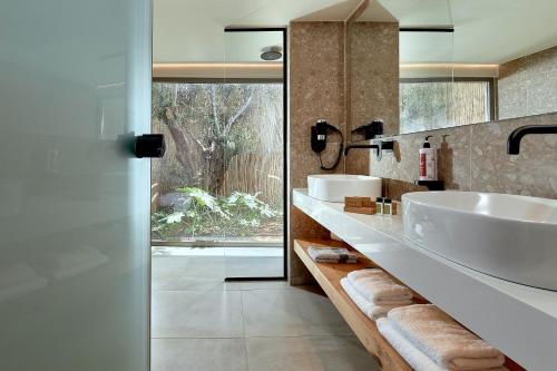 a bathroom with two sinks and a large window at Sentido Amounda Bay in Amoudara Herakliou