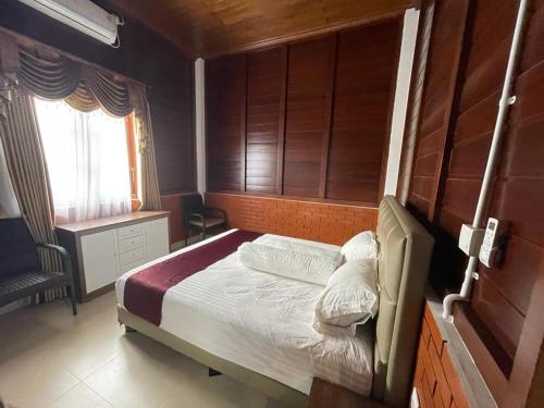 een kleine slaapkamer met een bed en een raam bij Villa Arjuna 