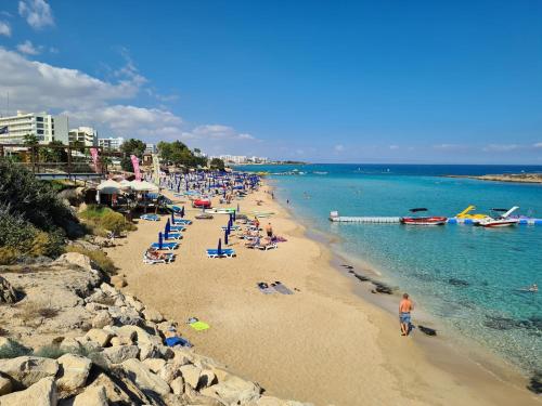 a beach with a bunch of people on the water at Sidra's Apartment in Paralimni