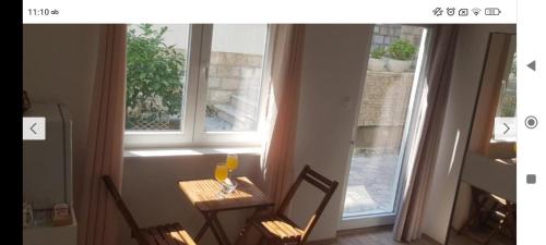 einem Tisch mit zwei Stühlen vor einem Fenster in der Unterkunft Zorić Apartments & Rooms 2 in Dubrovnik